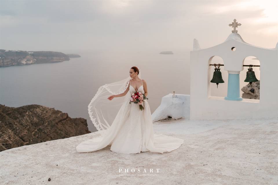 bride next to a chapel bell in santorini