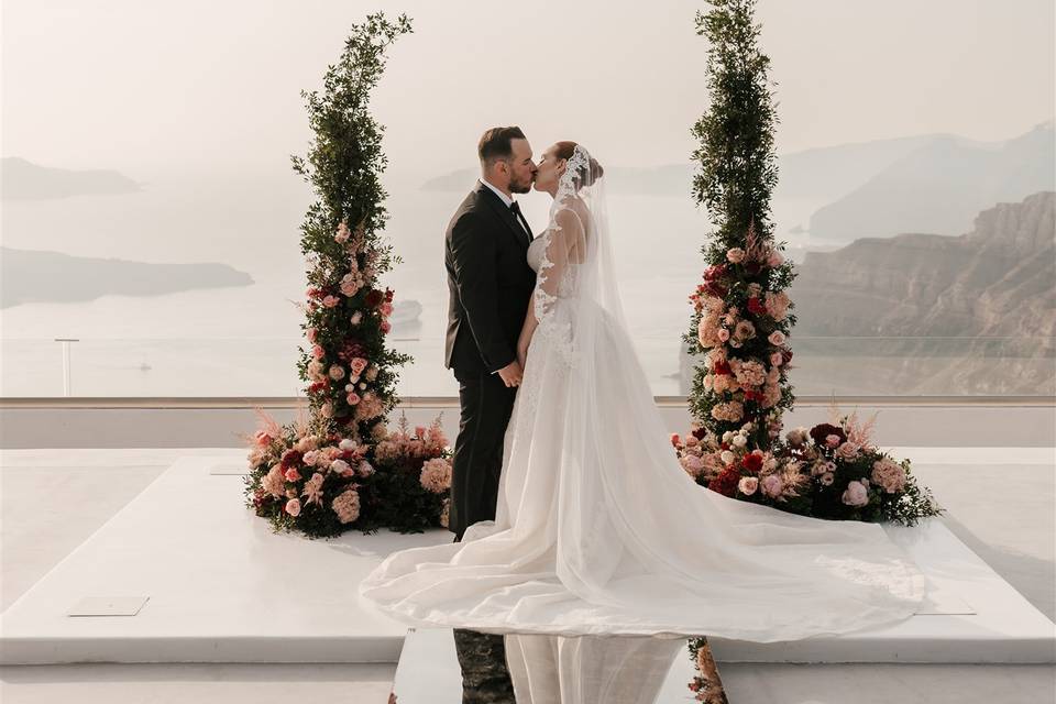 bride and groom kissing in santorini