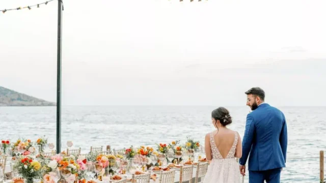 a newlywed couple holding hands admiring the decorations for their greece destination wedding