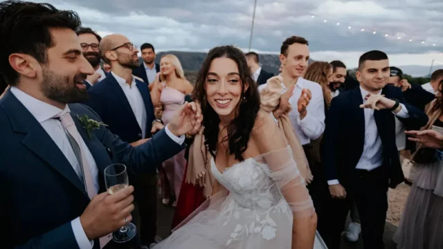 a bride smiling at her greek wedding surrounded by guests