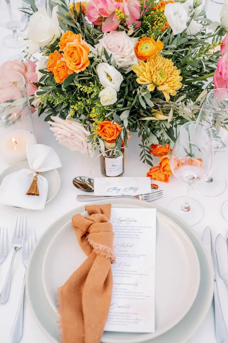 a complementary wedding table color scheme with orange, yellow, white, and coral colors