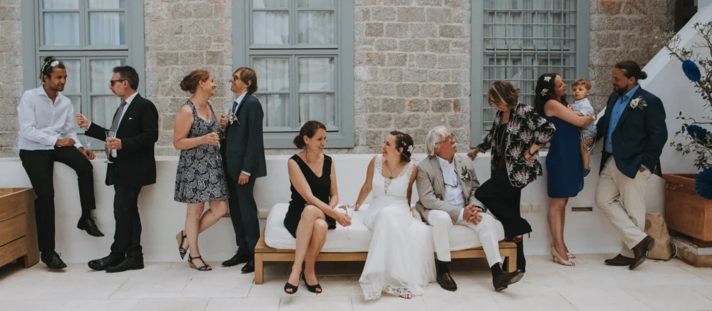 a bride and her guests casually sitting around talking at a wedding reception with everyone smart casually dressed