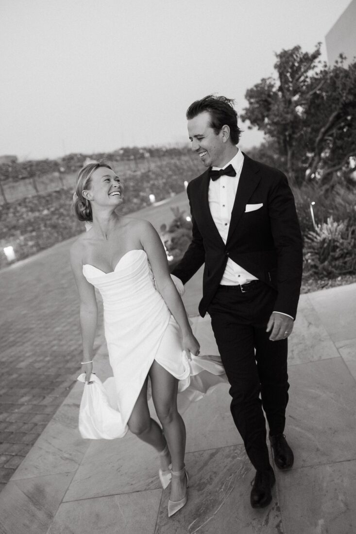Black and white photo of a laughing couple walking along a path together