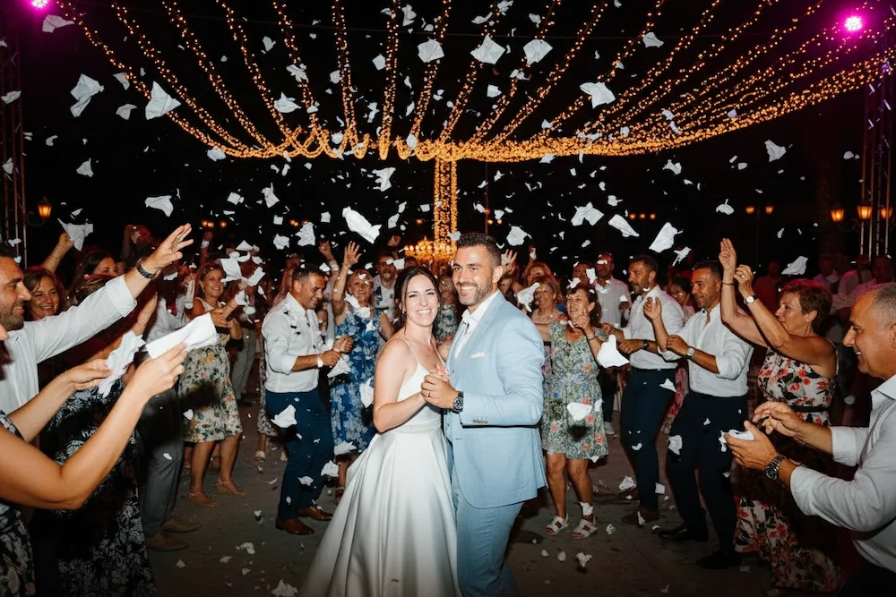 bride and groom being showered with napkins in the evening on the dance floor at a greek wedding