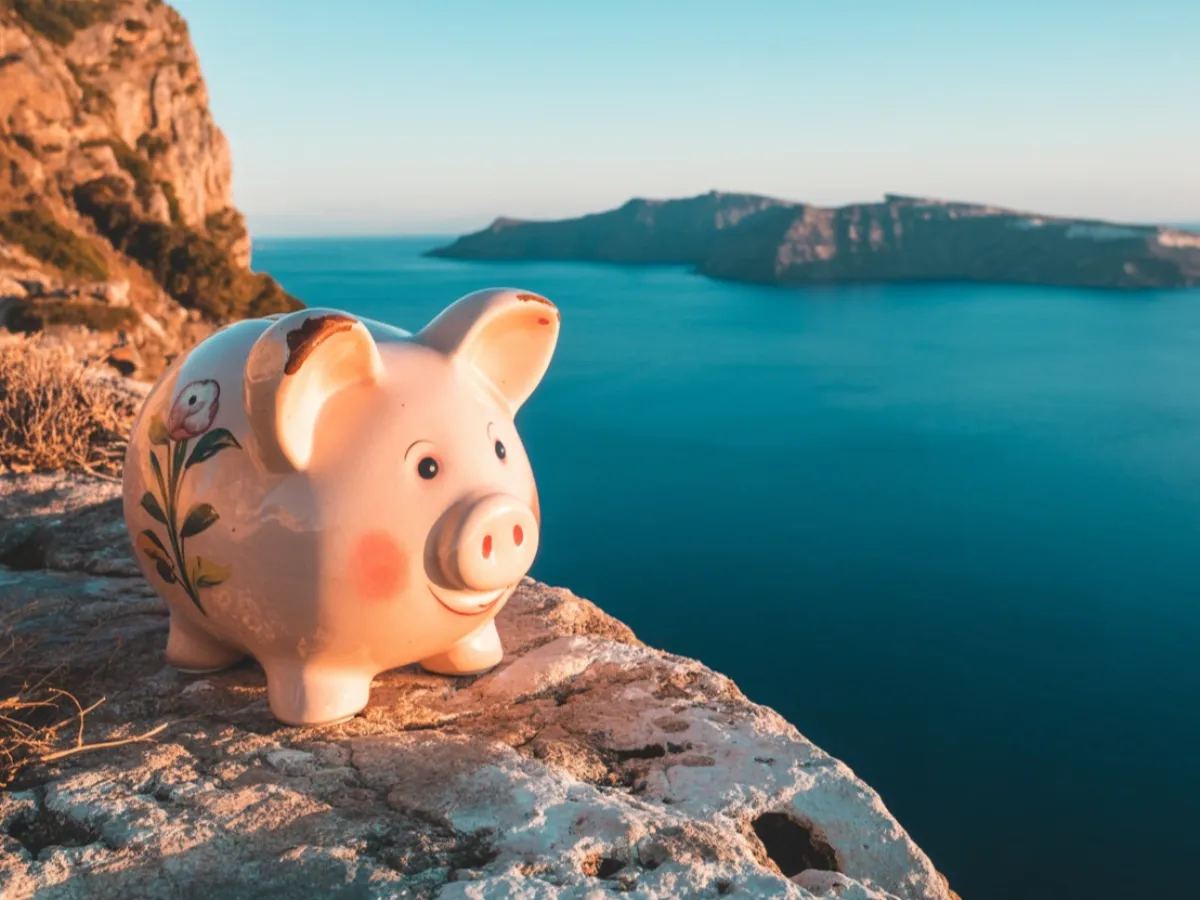 Greece destination wedding budget calculator little piggybank overlooking the mediterranean sea