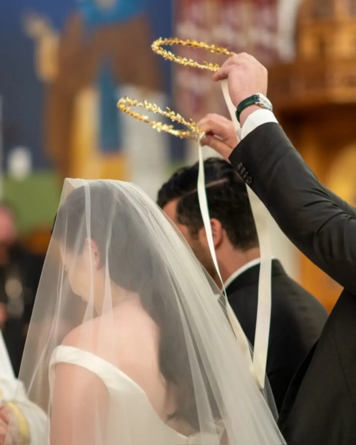 greek orthodox wedding with the koumbara switching the stefana three times during the ceremony