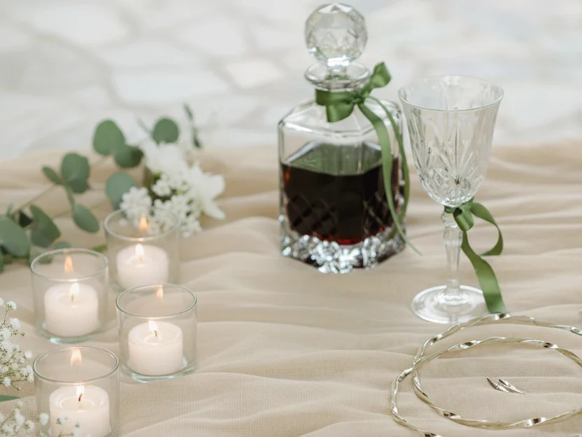 greek stefana laid out on a table next to a carafe and wine glass for a greek wedding ceremony
