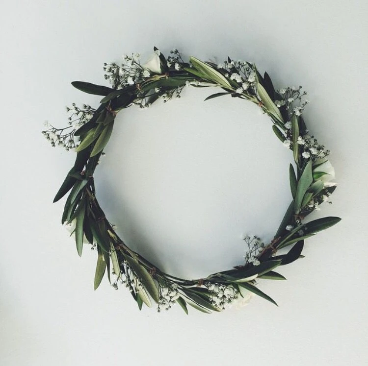 home made greek orthodox wedding stefana made from olive branches and flowers flat on a table