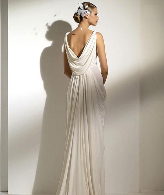 a bride in white wearing a greek goddess wedding dress with a draped open back