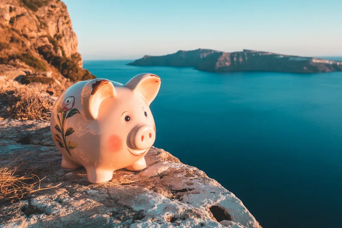 a hand-painted rustic piggy bank standing on a cliff in corfu greece