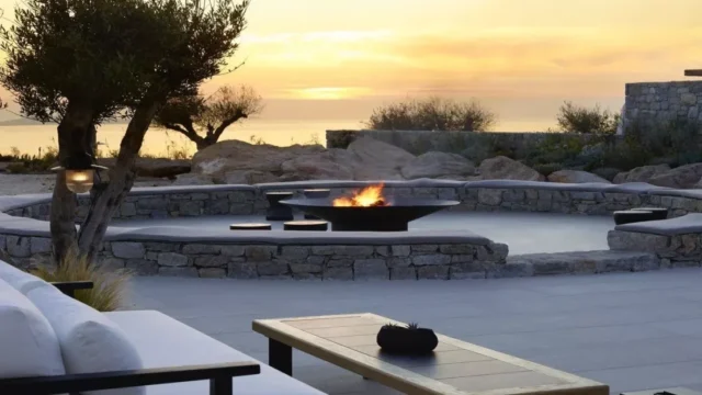 a firepit burns in the evening sunset glow at kalesma mykonos