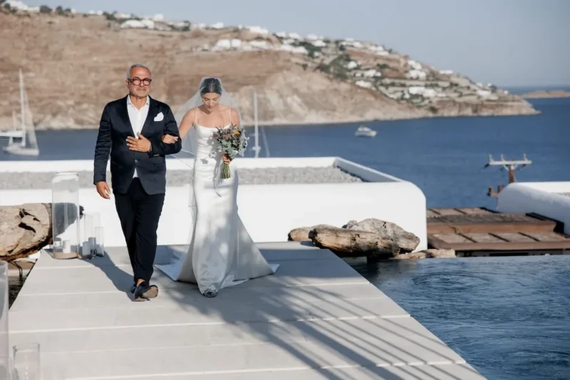 kalesma mykonos bride walking down the aisle with her father at a greek wedding in mykonos