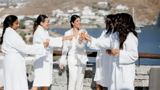 friends and bride toast at a wedding reception at kalesma mykonos at a wedding in greece