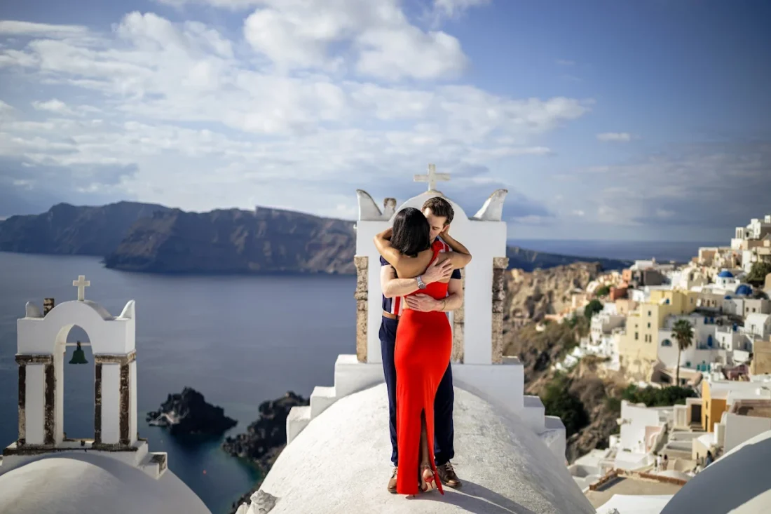 Honeymoon couple embracing on top of a church in santorini