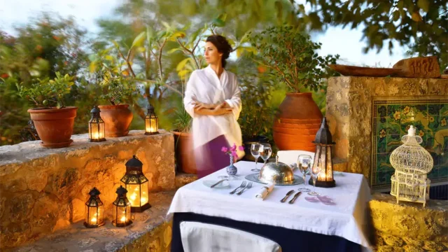 a lady standing over a table at the Melenos Art Boutique Hotel setup for a wedding in rhodes
