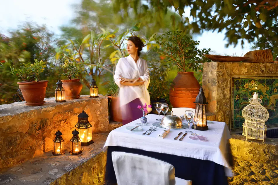 a lady standing over a table at the Melenos Art Boutique Hotel setup for a wedding in rhodes