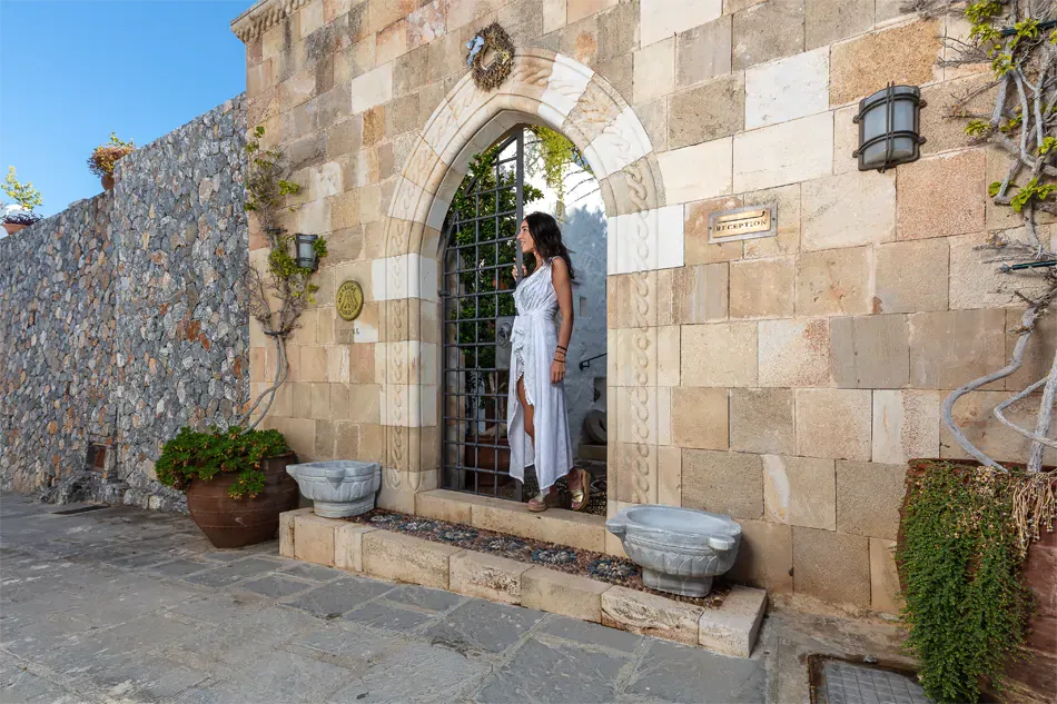 limestone archway with someone standing under it at the Melenos Art Boutique Hotel setup for a wedding in rhodes