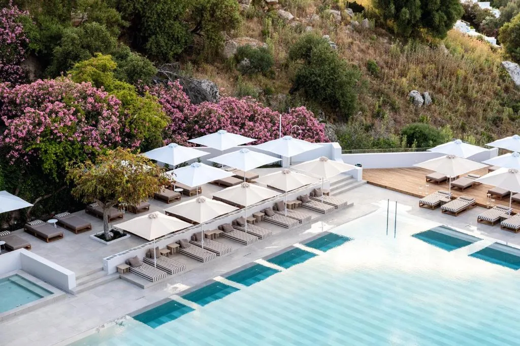 outdoor sun umbrellas and the pool at the Lindos Mare, Seaside Hotel in Rhodes