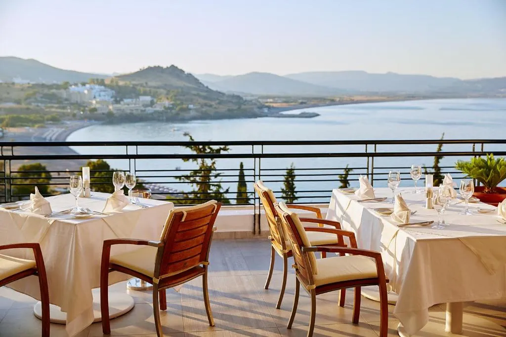 a view of chairs and dining table at the Lindos Mare, Seaside Hotel in Rhodes