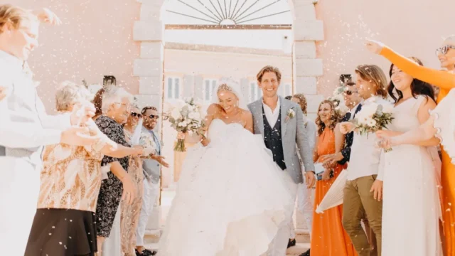 A newlywed couple exiting the courti esate in corfu surrounded by people