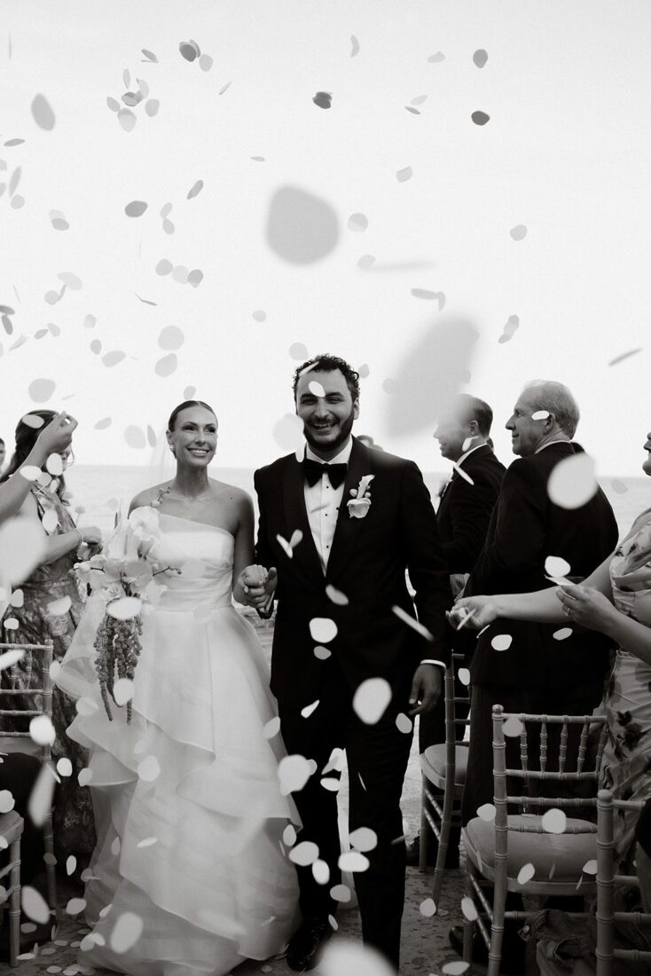 Kendall and Taylor walk through a confetti exit after their Sifnos wedding ceremony