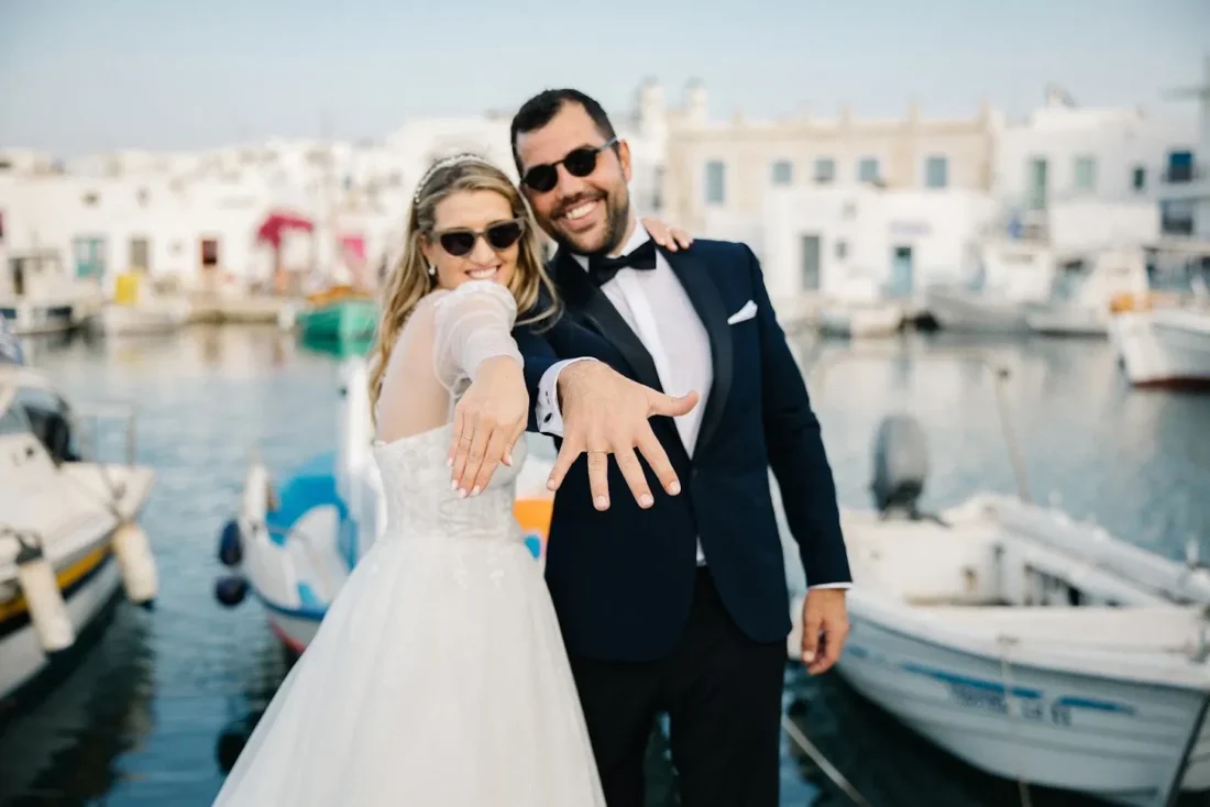 A newly married couple showing their wedding rings at the fishing harbour in Naoussa, Paros