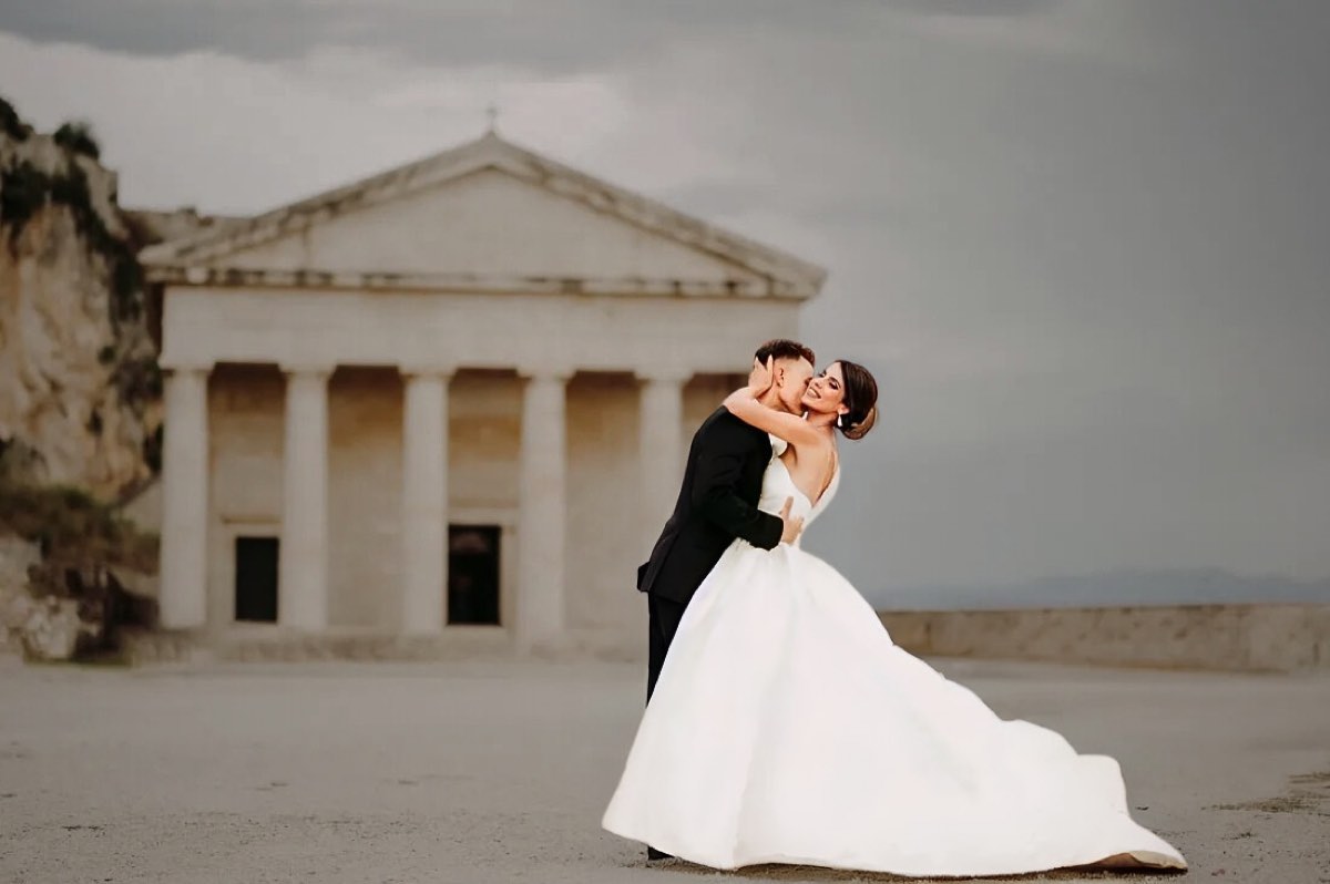 Couple embracing in front of a Greek temple