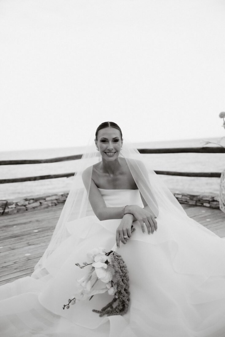 Bride seated with her bouquet and veil at Lazarou Beach, Sifnos