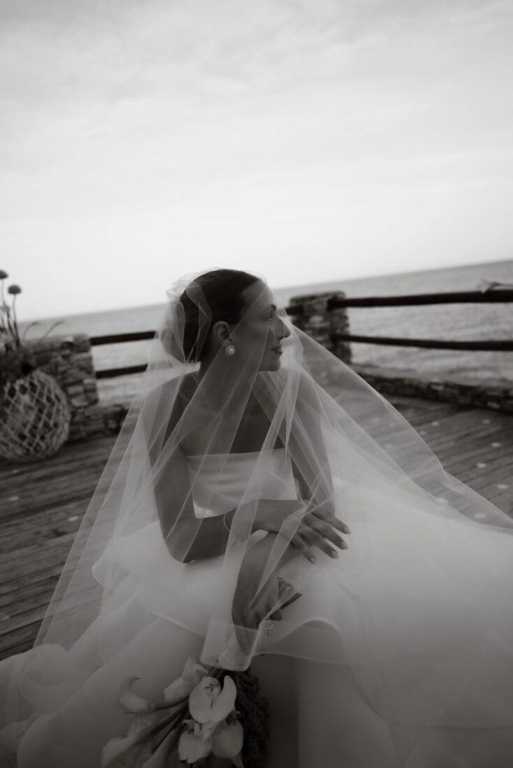 Bride from behind with her veil overlooking the sea at a Sifnos wedding