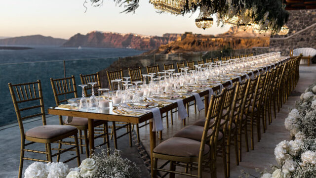 Long dinner table dressed with greenery on the terrace at Cavo Ventus, Santorini