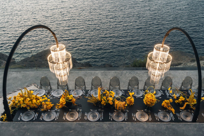 Dinner tables with hanging chandeliers and flowers at Cavo Ventus, Santorini