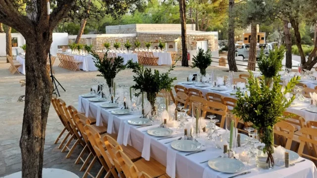 Long tables dressed with olive branches at dusk at Kaminari Village, Rhodes