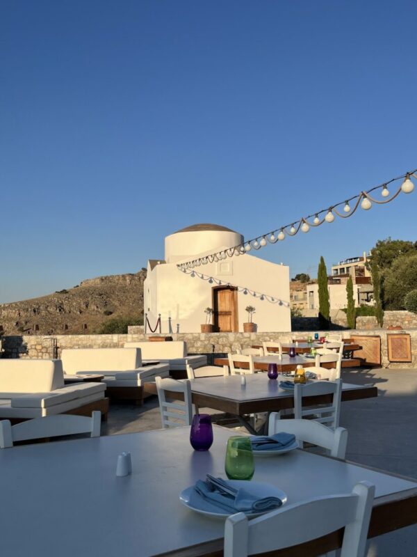 Lounge seating and dining tables on the terrace at dusk at Ktima Lindos, Rhodes