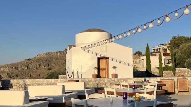 Lounge seating and dining tables on the terrace at dusk at Ktima Lindos, Rhodes