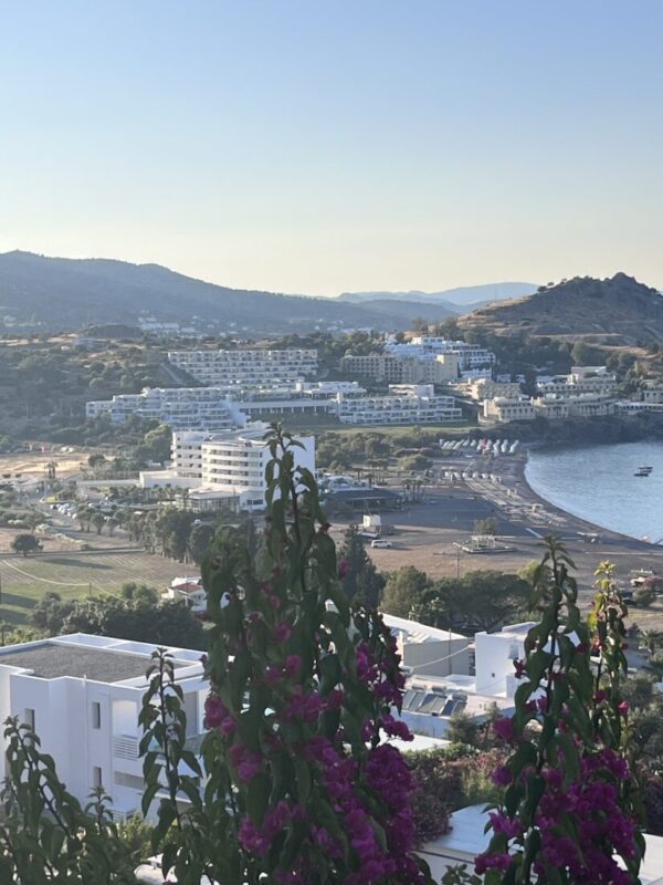 The view down over Vlicha bay from Ktima Lindos, framed by bougainvillea