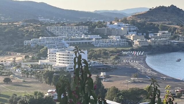 The view down over Vlicha bay from Ktima Lindos, framed by bougainvillea