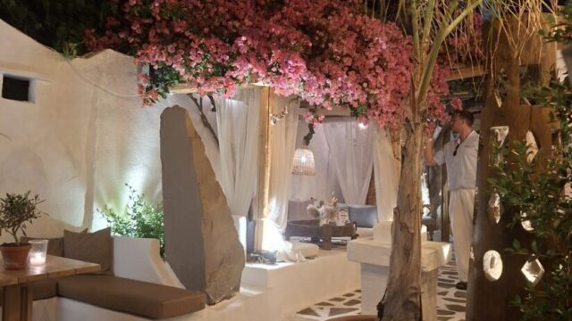 Lit courtyard with flowering trees in the evening at Lythos, Rhodes
