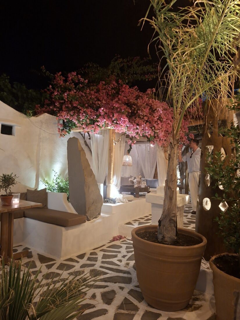 Lit courtyard with flowering trees in the evening at Lythos, Rhodes