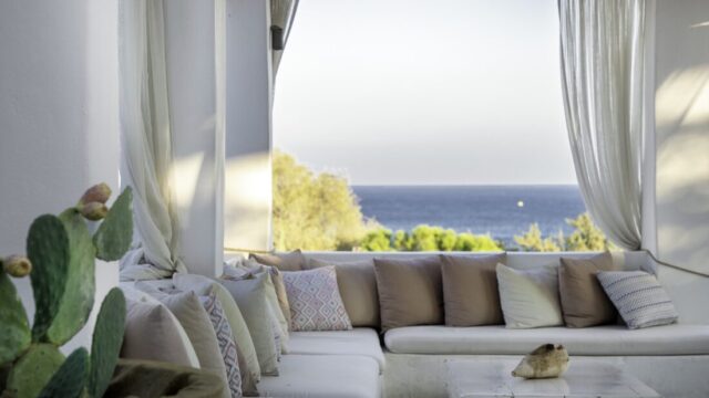 Lounge seating framed by curtains looking out to the Aegean at Lythos, Rhodes