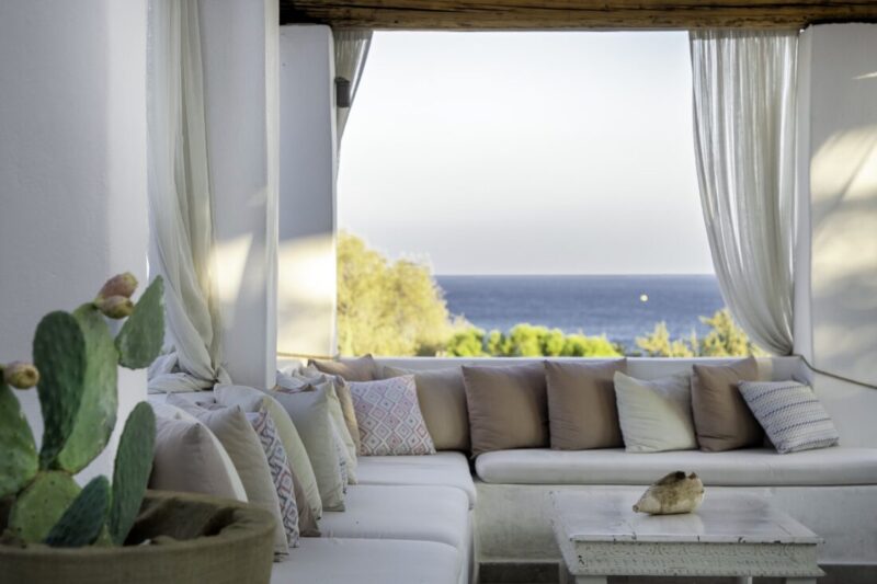 Lounge seating framed by curtains looking out to the Aegean at Lythos, Rhodes