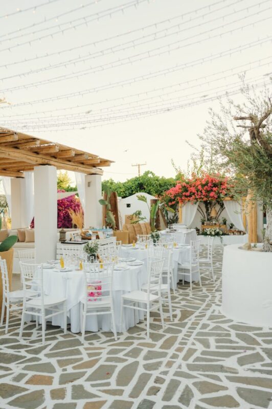 Reception tables and white chairs set for a wedding at Lythos, Rhodes