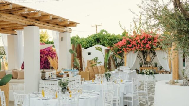 Reception tables and white chairs set for a wedding at Lythos, Rhodes
