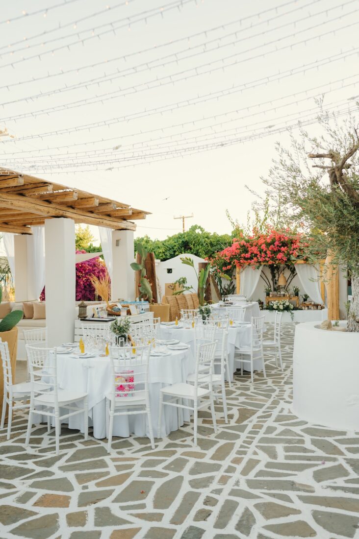 Reception tables and white chairs set for a wedding at Lythos, Rhodes