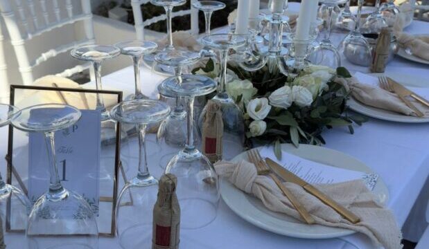 Wedding table set with white linen and greenery at Lythos, Rhodes