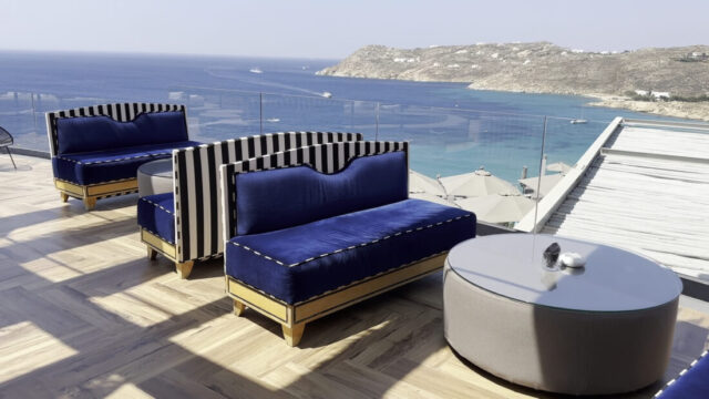 Terrace loungers looking over Elia Beach at Royal Myconian, Mykonos
