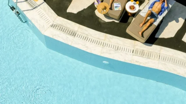 Aerial view of poolside sunbeds and parasols at Royal Myconian, Elia Beach, Mykonos