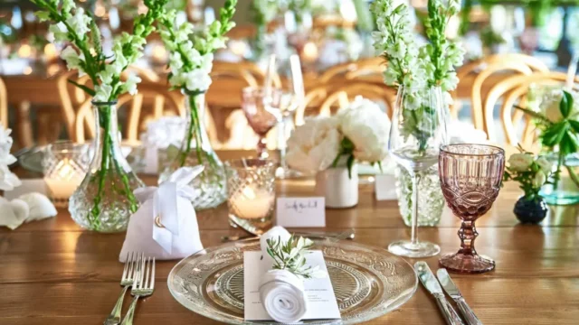 Wedding table setting with white flowers, candles and glassware at Royal Myconian, Mykonos
